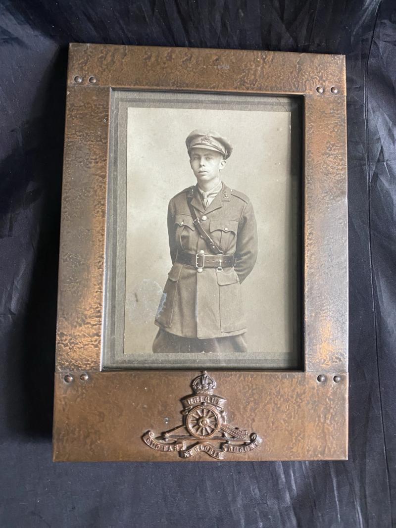 BRASS PICTURE FRAME WITH ROYAL ARTILLERY INSIGNIA WITH A PICTURE OF A SOLDIER